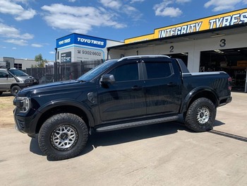  Black Ford Ranger Raptor equipped with all-terrain tyres and side steps