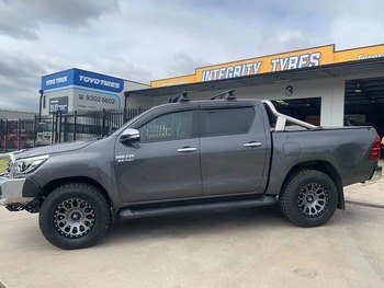  Grey Toyota Hilux side profile with aftermarket wheels and all-terrain tyres